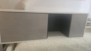 Mueble de salón gris y blanco.  Con dos puertas.