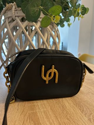 Bolso negro con logo dorado
