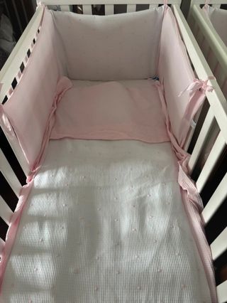 Ropa de cuna rosa y blanca