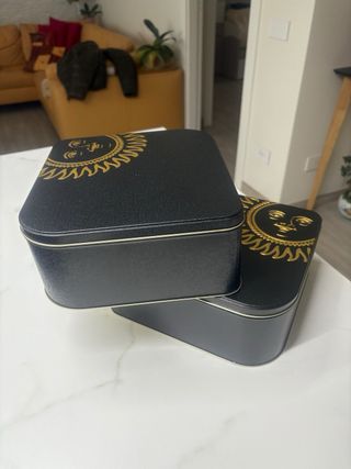 2 scatole di latta con sole dorato