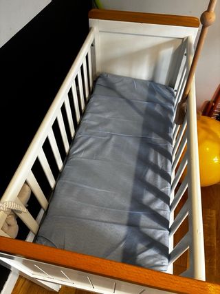 Cuna de madera blanca con ruedas