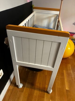 Cuna de madera blanca con ruedas