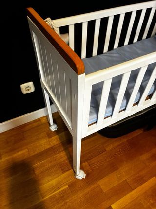 Cuna de madera blanca con ruedas