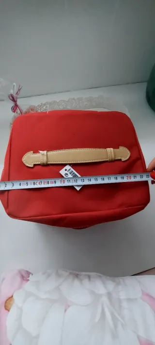 Neceser rojo unisex, con asa de color piel.