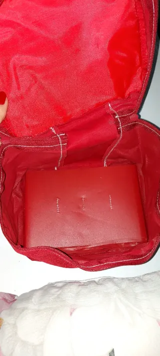 Neceser rojo unisex, con asa de color piel.