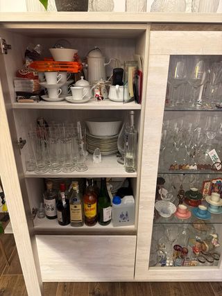 Alacena blanca rota con puertas de madera.