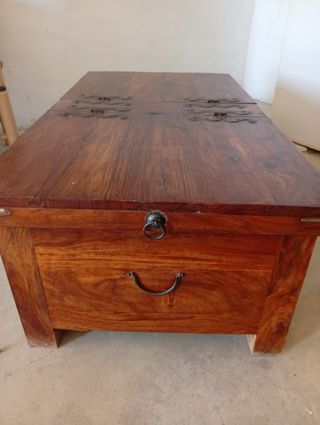 Baúl de madera con detalles metálicos en negro.