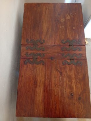 Baúl de madera con detalles metálicos en negro.