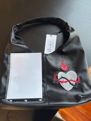 Bolso de piel negro con tachuelas y dibujo bordado