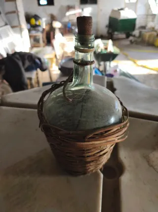 Botella de vidrio con cestería