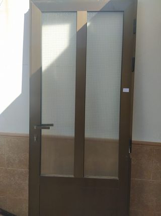 Puerta aluminio bronce con cristal reforzado