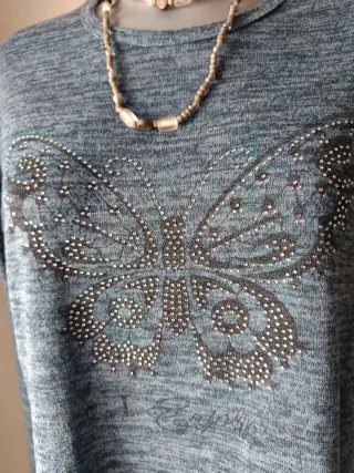 Jersey azul con mariposa de strass.
