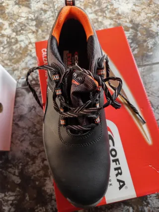 Zapatos de seguridad COFRA negros y naranjas.