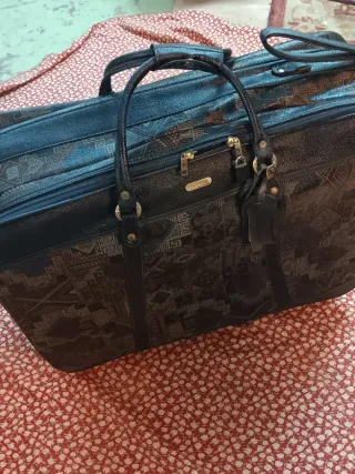 Maleta de viaje negra y dorada