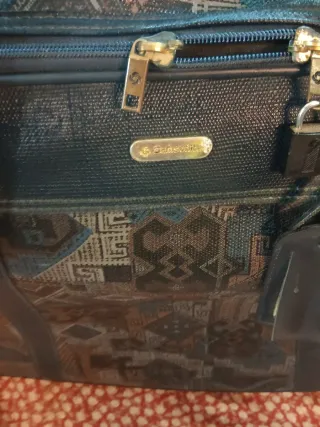 Maleta de viaje negra y dorada