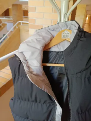 Chaleco acolchado negro con detalles rosas