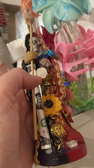 Santa Muerte con billetes y girasol
