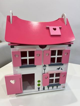 Casa de muñecas de madera rosa y blanca