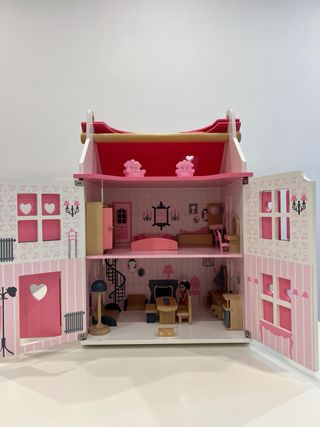 Casa de muñecas de madera rosa y blanca