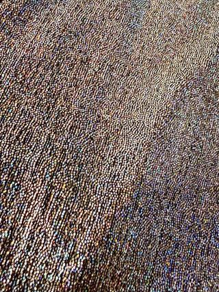 Top asimétrico plateado con manga abullonada.