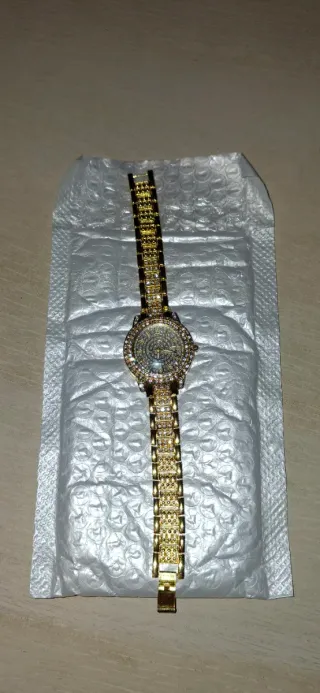 Reloj dorado con pedrería