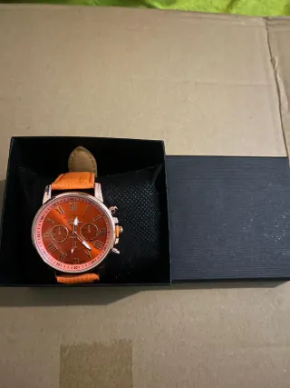Reloj de pulsera naranja y dorado