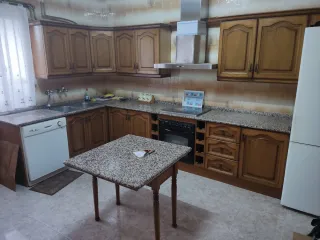 Cocina de madera con encimera de granito.
