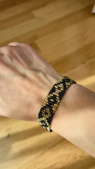 Pulsera tejida de cuentas doradas y negras