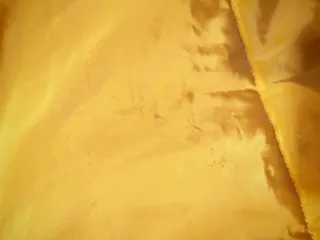 Plumífero largo mostaza con capucha