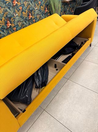 Sofá cama amarillo con departamentos