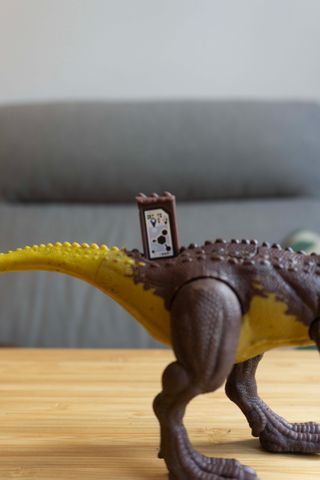 Dinosaurio de juguete marrón y amarillo