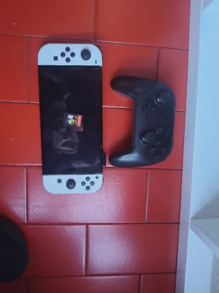 Nintendo Switch OLED Bianca e Nera con il controller