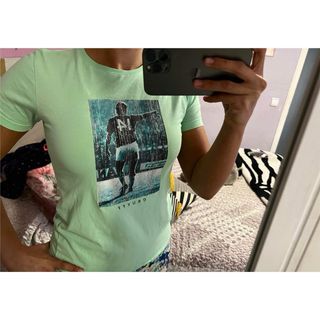 Camiseta azul-verde claro con estampado.