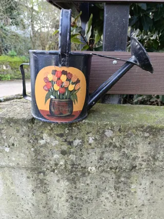 Regadera de metal decorada con flores