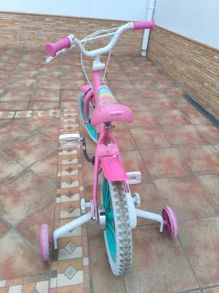 Bicicleta infantil rosa con ruedines