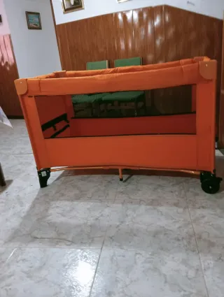 Cuna de viaje naranja con mosquitera