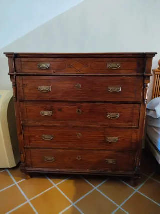 Cómoda antigua en madera con acabados tallados.