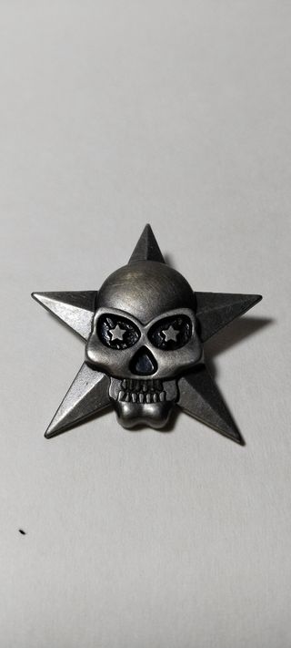 Broche calavera sobre estrella cinco puntas