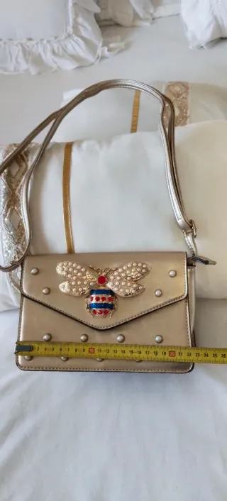 Bolso bandolera dorado con diseño joya