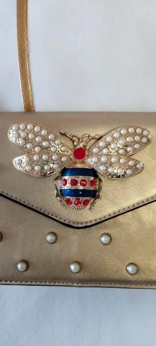 Bolso bandolera dorado con diseño joya