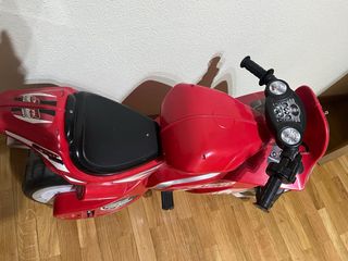 Moto a batería infantil roja, lleva dos ruedines.