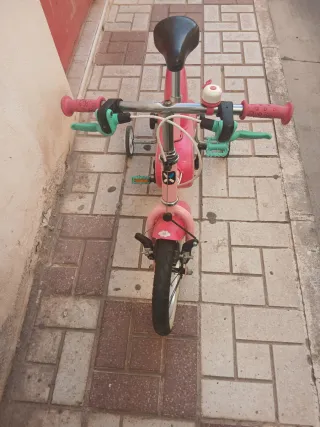 Bicicleta infantil rosa con ruedines