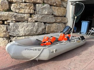 Barca hinchable gris con remos y chalecos