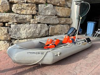 Barca hinchable gris con remos y chalecos