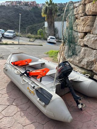 Barca hinchable gris con remos y chalecos