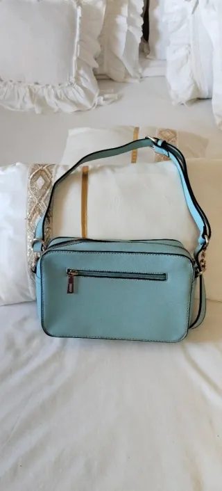 Bolso bandolera azul claro con asa.