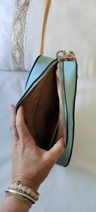 Bolso bandolera azul claro con asa.