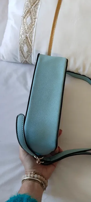 Bolso bandolera azul claro con asa.