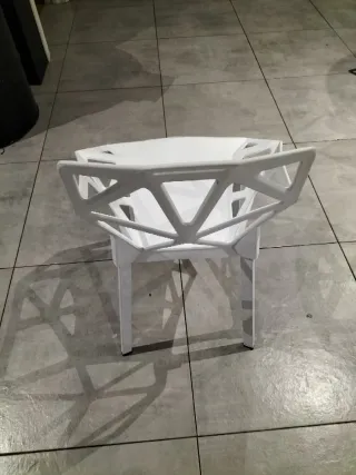 Silla baja blanca de plástico y metal.