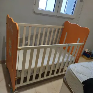 Cuna infantil naranja con dibujo de león